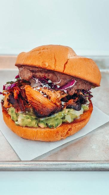 PORK BELLY CARNITAS TORTA · Refried Black Beans, Smashed Avocado, Red Cabbage Salad, And Queso Fresco