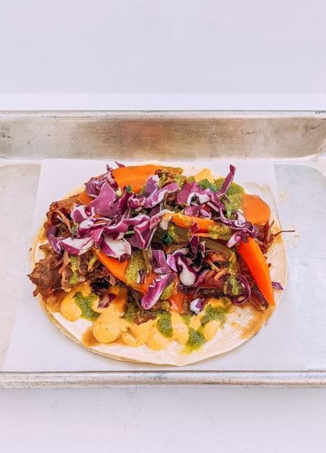 LUCY TACO · Lemongrass Braised Pork, Escabeche (Pickled Carrot & Jalapeno), Aji Aioli, Ginger Chimi, & Red Cabbage Salad. Served On Gluten-Free White Corn Tortillas