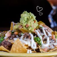 Beef Nachos · Tortilla chips topped with beans, beef, Monterey Jack cheese, jalapenos, pico de gallo, guac...