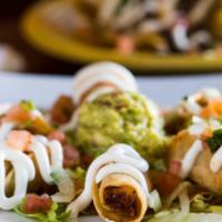Taquitos Dorados de Papa · 5 hard shell potato taquitos topped with shredded lettuce, Cotija cheese, and salsa.