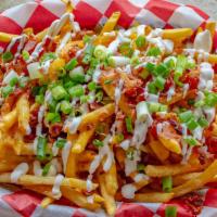 Loaded Fries · Covered in nacho cheese and topped with bacon, chives and a drizzled with sour cream.