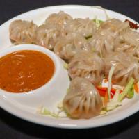 Chicken Momo · Steamed bun filling with ground chicken served with sesame and roasted tomato chutney.