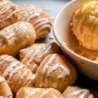 Cinnabites · Freshly baked cinnamon & sugar bites drizzled with vanilla sauce, & served with ice cream to...