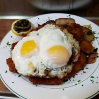 Schnitzel a la Holstein · Veal cutlets, breaded and fried, topped with fried eggs, anchovies and capers, served with G...