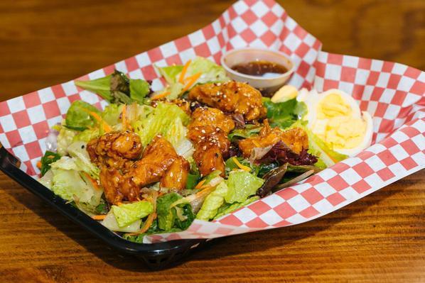 Sesame Ginger Chicken Salad · mixed greens, carrots, diced onions, sliced eggs, shredded cheese, tossed in sweet sesame ginger dressing, topped with crispy sesame chicken