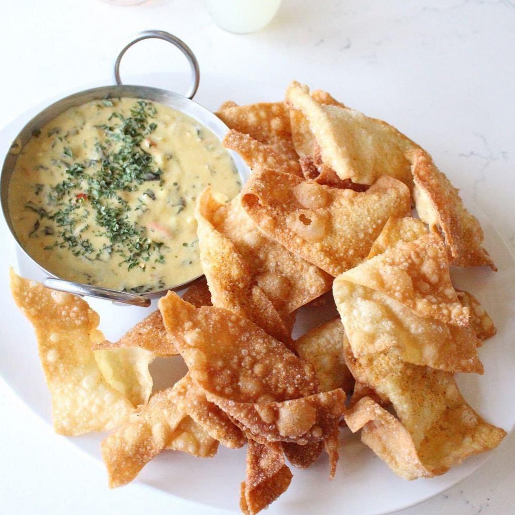 West Downtown Dip · A melted blend of white cheese, spinach, green chilies, red pepper, tomatoes, onion and spices with wonton chips.