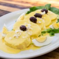 Papa a la Huancaina · Slices of boiled potatoes topped with Aji Amarillo chili and cheese sauce, garnished with Qu...