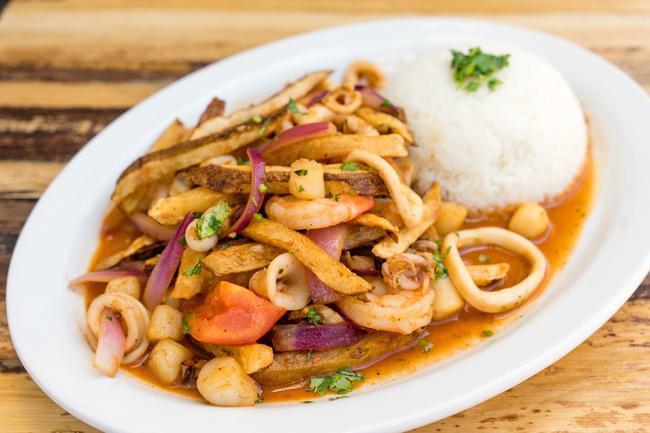 Saltado de Mariscos · Stir fried mixed seafood, onions, tomatoes, fried potatoes, cilantro and soy sauce, served with garlic white rice.