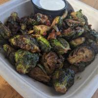 Brussel Sprouts · Crispy Brussel sprouts tossed with spiced honey and bacon bits.   
