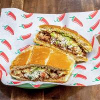 Torta con Carne · Telera bread sandwich with your choice of meat, beans, Cotija cheese, avocado, jalapenos, on...