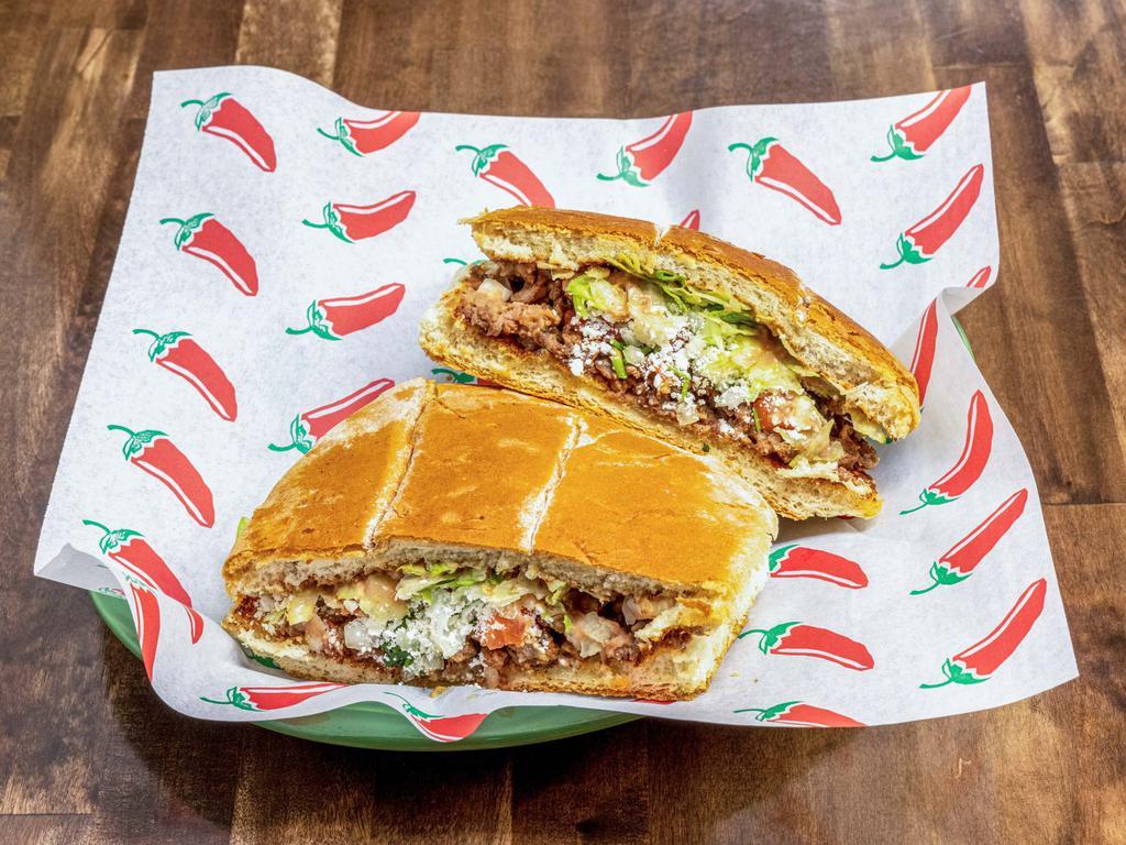 Torta con Carne · Telera bread sandwich with your choice of meat, beans, Cotija cheese, avocado, jalapenos, onions, cilantro, and tomatoes.