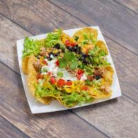 Taco Salad · Corn chips topped with a choice of meat, shredded lettuce, cheese, diced tomatoes, sliced bl...