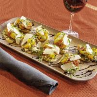 Bruschetta · Toasted baguette slices topped with homemade pesto, fresh cherry tomatoes, julienne basil, g...