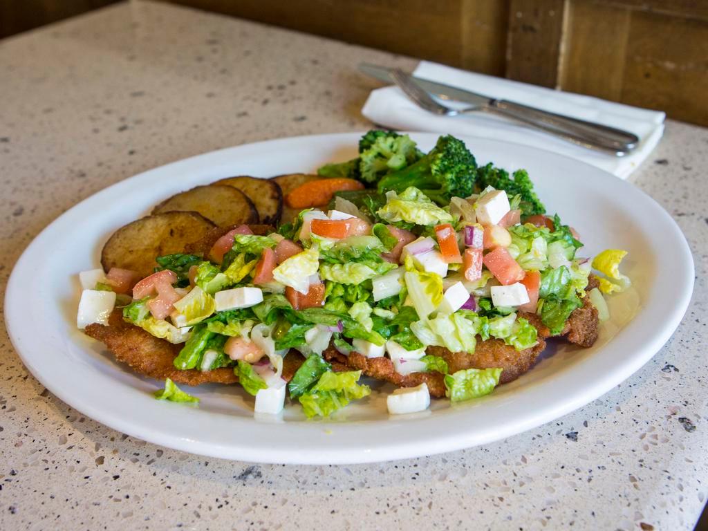 Semi Freddo · Golden fried chicken or veal cutlet topped with romaine, tomatoes, red onions & fresh mozzarella. Served with potato and vegetable of the day.