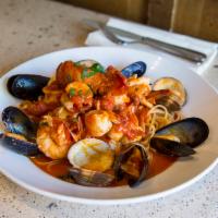 Zuppa Di Pesce · Shrimp clams, mussels, lobster tail and calamari sauteed in marinara sauce and served over l...