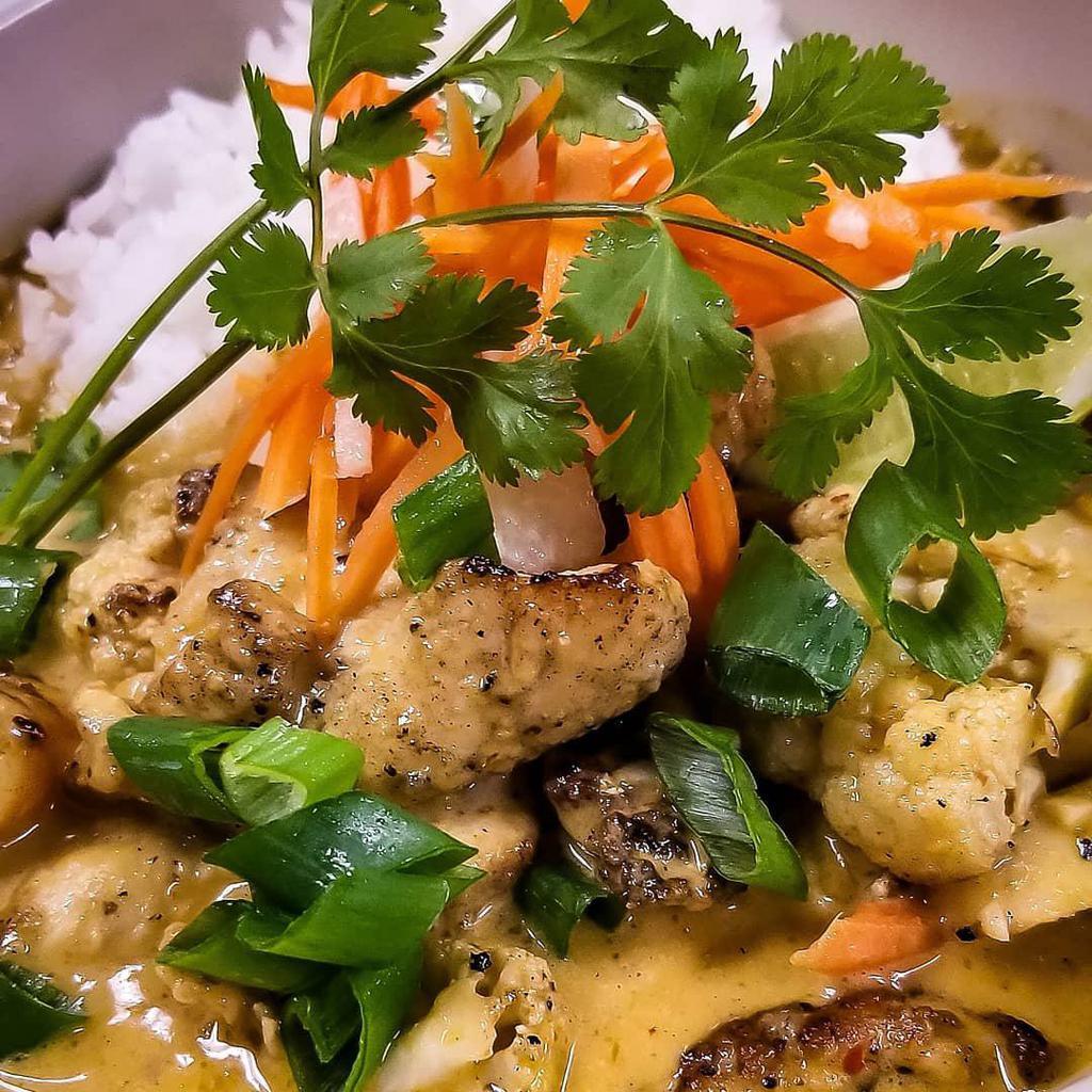 Chicken Curry Rice Bowl · Slightly spicy, creamy and flavorful curry made with coconut cream, seasoned vegetables over steamed rice. 
Topped with pickled veggies, green onions and cilantro