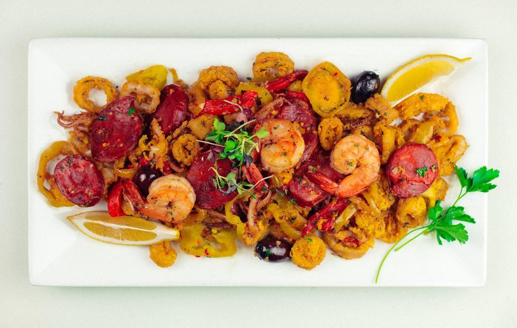 Calamari di Cabo Verde · Fried calamari blended with sautéed shrimp, chorizo, banana peppers, olives and red bell peppers. Served with garlic aioli & spicy mango sauce