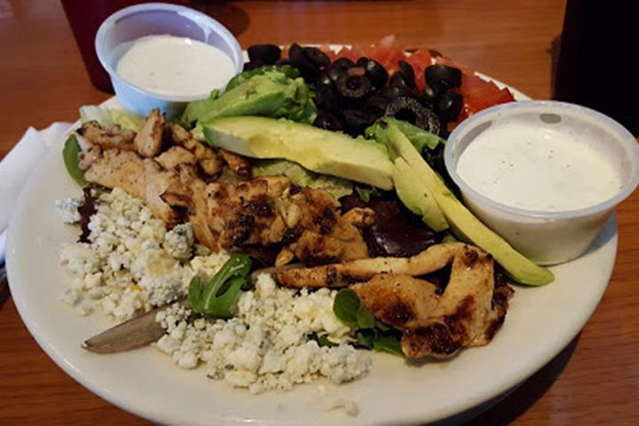 Cobb Salad · Fresh mixed greens topped with grilled chicken, diced tomatoes, black olives, sliced avocado, hard-boiled eggs, and bleu cheese crumbles served with our house bleu cheese dressing.