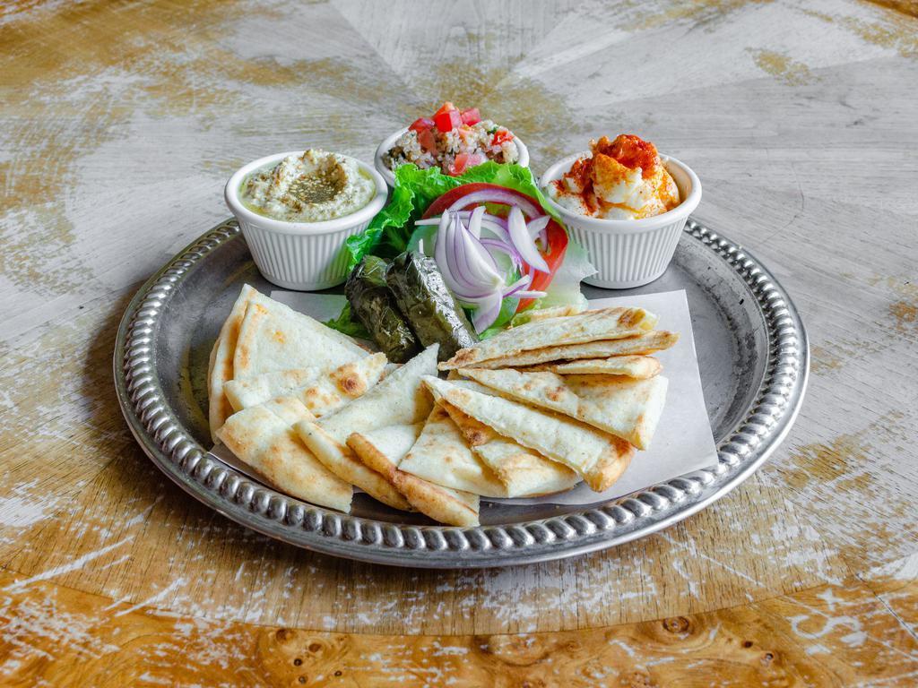 Mezza Platter · Toasted pita, hummus, garlic spread, quinoa tabbouleh, grape leaves, herbs, and spices. Vegan.

