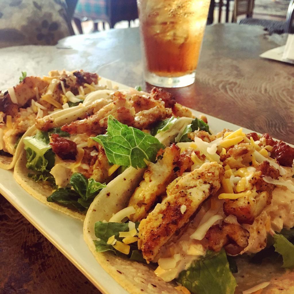 Spicy Chicken Tacos · Spicy grilled chicken, Sriracha slaw, cheddar jack, romaine, and corn tortilla. Spicy. Gluten-free.