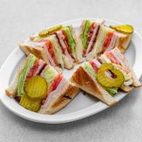 Turkey Club Sandwich · A large portion of sliced turkey and 3 slices of thick pork bacon served on 3 pieces of the ...