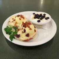 Eggs Blackstone · Grilled tomatoes with poached eggs and crumbled bacon on a toasted English muffin.