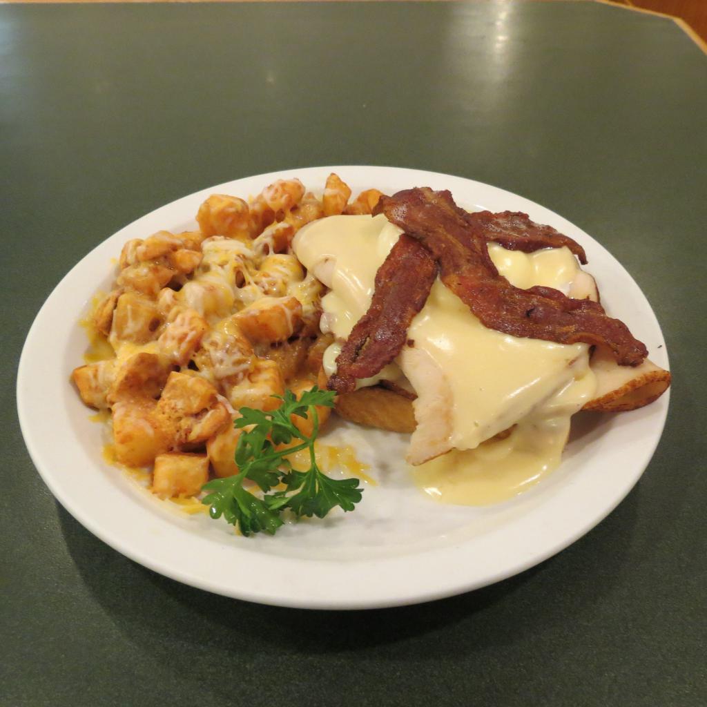 Kentucky Hot Brown · Grilled Texas toast served with grilled turkey and a poached egg. Top it all off with creamy hollandaise sauce, 2 strips of bacon and a breakfast side.