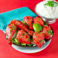 Tandoori Chicken · Chicken marinated in yogurt and spices, cooked in the clay oven and served on a sizzling pla...