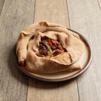 17. Derek Tibs · Chopped prime beef marinated with Adama special sauce, onions, tomatoes and peppers cooked w...