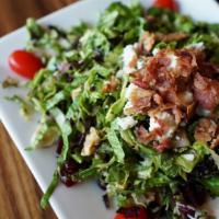Gorgonzola Chopped Salad · Chopped lettuces, red onion, walnuts, tomatoes, dried cranberries, warm bacon, and gorgonzol...