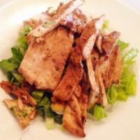 Pollo Caesar Salad · Strips of grilled marinated chicken breast over romaine salad, garlic croutons and creamy Ca...