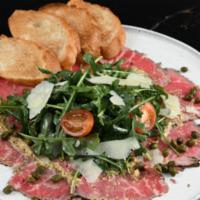 Beef Carpaccio · Rare Sliced thin, arugula, capers, red onions, shaved parmesan, spiced mustard sauce