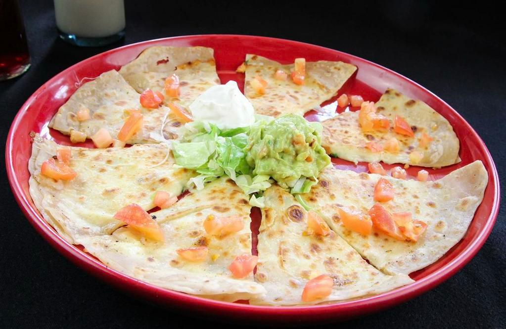 Quesadilla Grill · Soft flour tortilla stuffed with grilled chicken breast, melted cheese, fresh bell peppers and mushrooms. Served with tomatoes, lettuce, sour cream and guacamole.