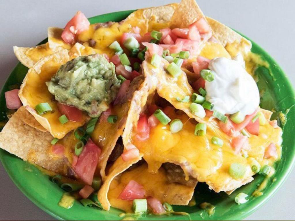 Nachos Casa  Hacienda · The house nachos with beans, tomatoes, onions and cheddar. Add chicken, ground beef, shredded beef or chorizo for an additional charge.