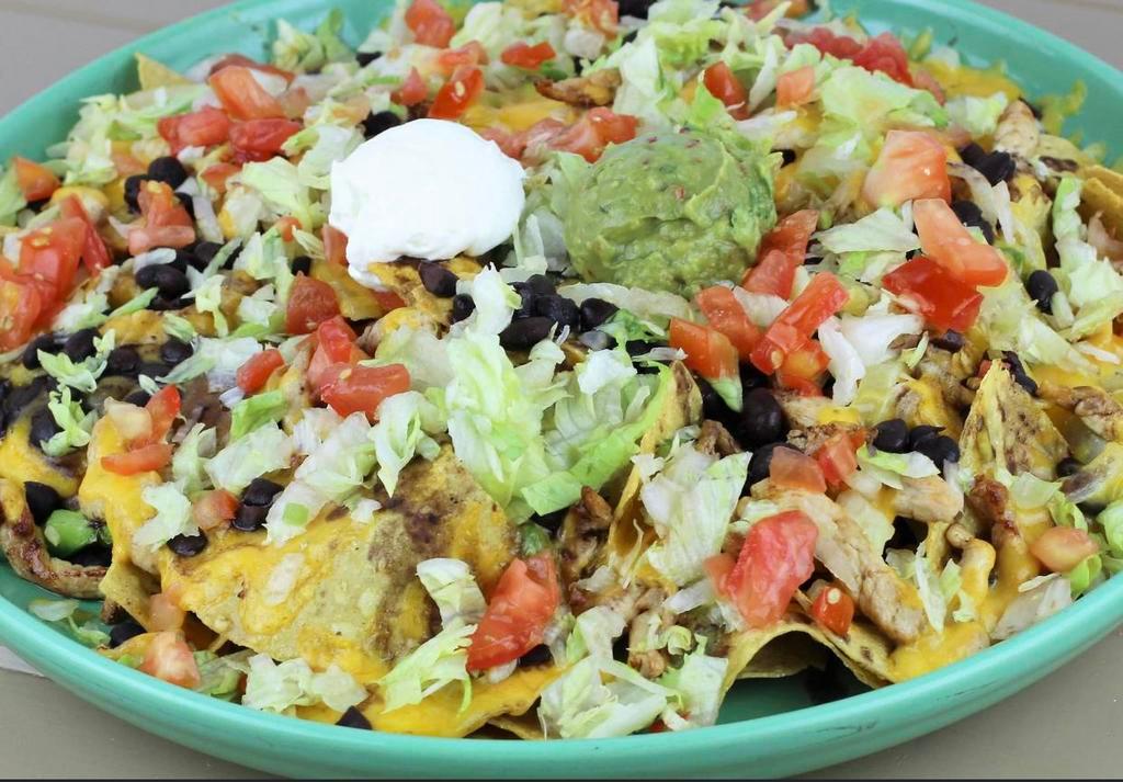 Fajita Nachos · A platter of fresh house made tortilla chips topped with your choice of marinated chicken or beef, grilled onions and bell peppers. Topped with black beans and garnished with lettuce, tomato, guacamole and sour cream.