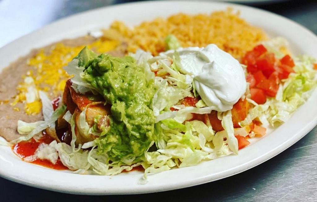 Burrito Deluxe · A flour tortilla filled with your choice of chicken, beef, shredded beef or pork. Smothered with green chili or burrito sauce and melted cheese. Topped with lettuce, tomatoes, chopped onions, guacamole and sour cream.