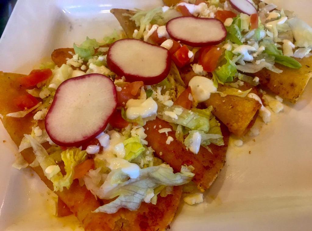 Enchiladas Mexicanas · 4 corn tortillas stuffed with your choice of chicken, ground beef or shredded beef. Topped with cabbage, ranchero cheese, sour cream sauce and radish.