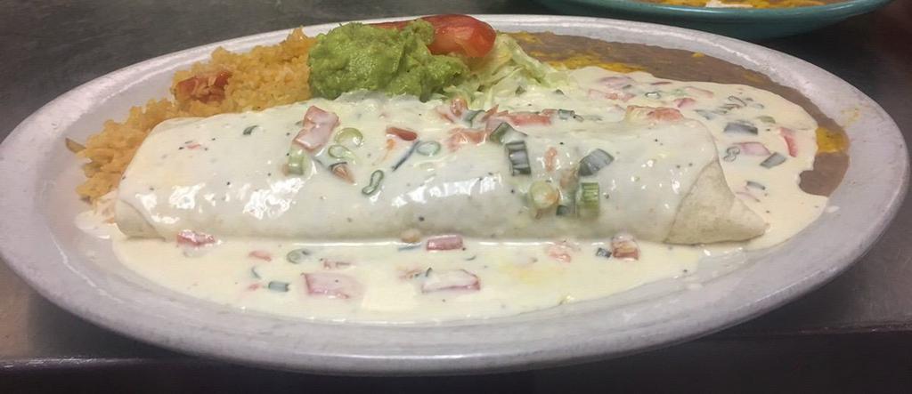 Seafood Burrito · Large flour tortilla stuffed with scallops, shrimp and crab meat. Topped with a special sauce and served with rice, beans, guacamole and sour cream.