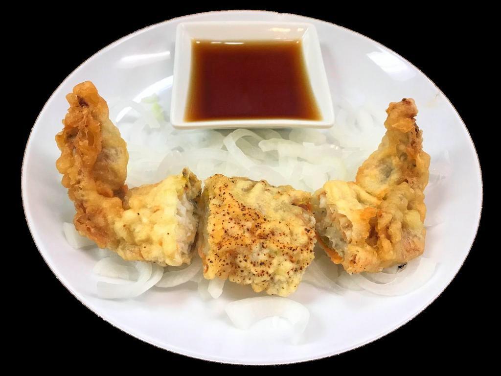 Soft Shelled Crab · Soft shelled crab lightly coated with tempura batter, served with thinly sliced onions and a tempura sauce.