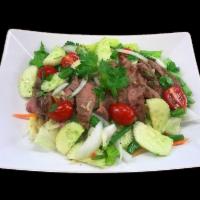 Thai Spicy Beef Salad · Slices of grilled tender beef dressed with Thai spicy lime sauce, garlic, chilies, cucumbers...