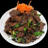 Mongolian Beef · Stir-fried beef with scallions and served in a sweet brown sauce on top of crispy noodles. S...