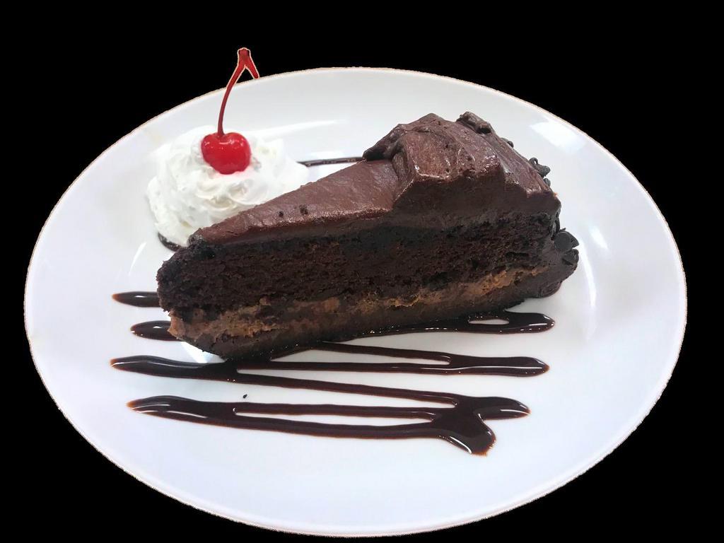 Ultimate Chocolate Cake · Velvety chocolate cake between layers of chocolate decadence and chocolate butter cake on a chocolate cookie crust finished with chocolate ganache and chocolate chips, decorated with chocolate syrup, whipped cream and a cherry on top.