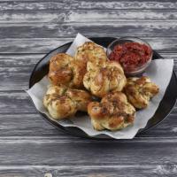 Garlic Knots · Handmade Dough Knots smothered in Garlic, Olive Oil and Oregano. Served with a side of our H...