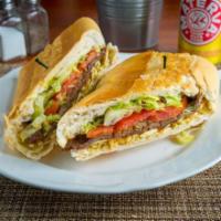 Sandwich con Bistec de Res · Sandwich de bistec de res con cebolla cocida, tomate, lechuga y papitas secas.