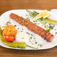 Midpoint Adana · Minced and seasoned lean lamb meat mounted on long flat skewers cooked on charcoal fire. Ser...