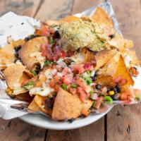 Nachos · Fried white-corn tortilla chips topped with a veggie black bean mix, white cheese blend, our...