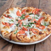 The Chicken Ranch Specialty Pizza · Grilled chicken, Roma tomatoes, basil, and rasher bacon with a ranch dressing sauce base.
