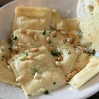 Salmon Raviolis · handmade pasta filled with baked salmon and ricotta cheese. Served with a garlic lemon butte...
