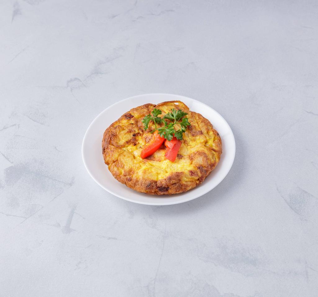 Tortilla española · Spanish omelette with eggs,chopped crispy potatoes, white onions and artisanal sausage baked