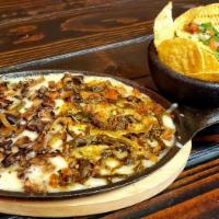Queso Fundido  ( Pictured melted jack cheese with 1/2 mushrooms 1/2 poblano rajas) · Melted Monterey Jack cheese on a skillet with chorizo (Mexican sausage) or  Vegetarian optio...
